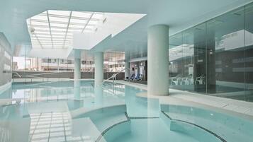 Alberca techada, alberca al aire libre y camastros