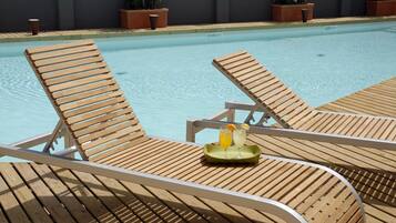 Alberca techada, alberca al aire libre y camastros