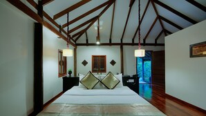 A bedroom with a large bed, wooden beams, a nightstand, and a window with shutters. - Bunwin Residence (Siem Reap)
