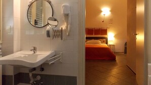 A hotel bathroom with a sink, mirror, and towel dispenser. - Hostel Colours (Milan)