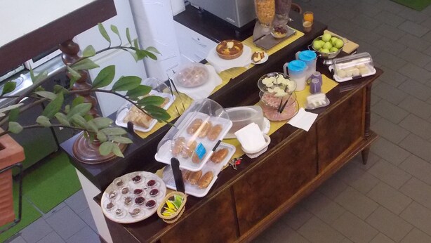 A buffet table with various food items and condiments. - Hostel Colours (Milan)