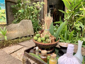 A traditional altar with a bowl of offerings, including fruits and spices, set on a stone platform.