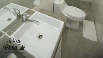 Une salle de bain avec un lavabo, un miroir et des toilettes.