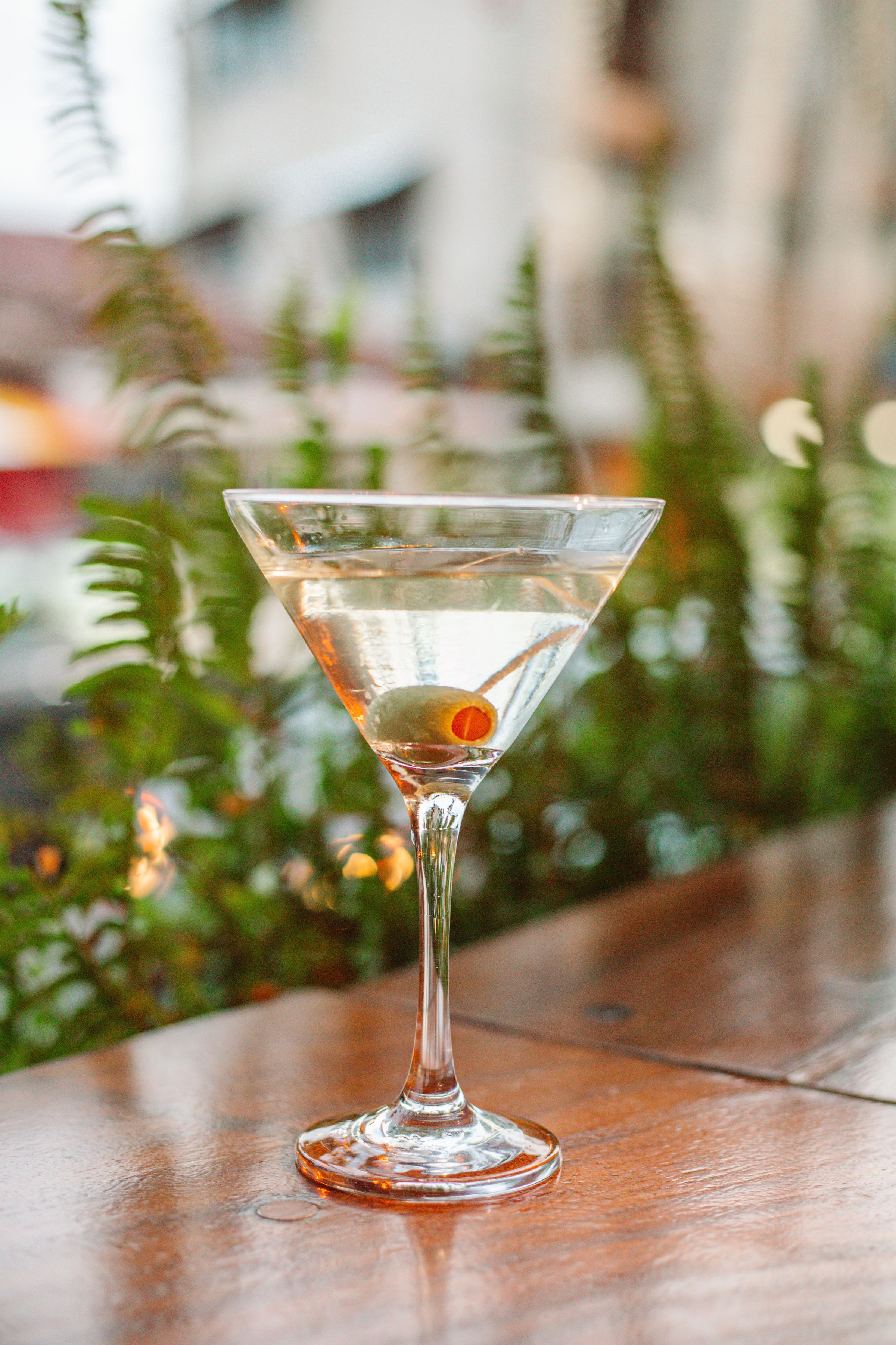 Un verre à martini avec une tranche de citron sur une table en bois.
