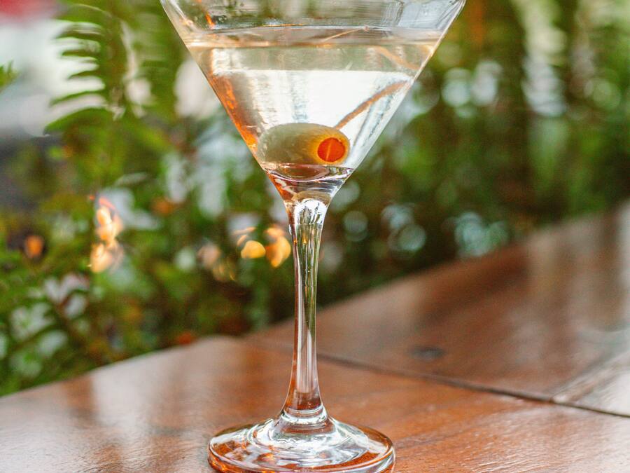 Martini-lasi, jossa on sitruunaviipale, puupöydällä.