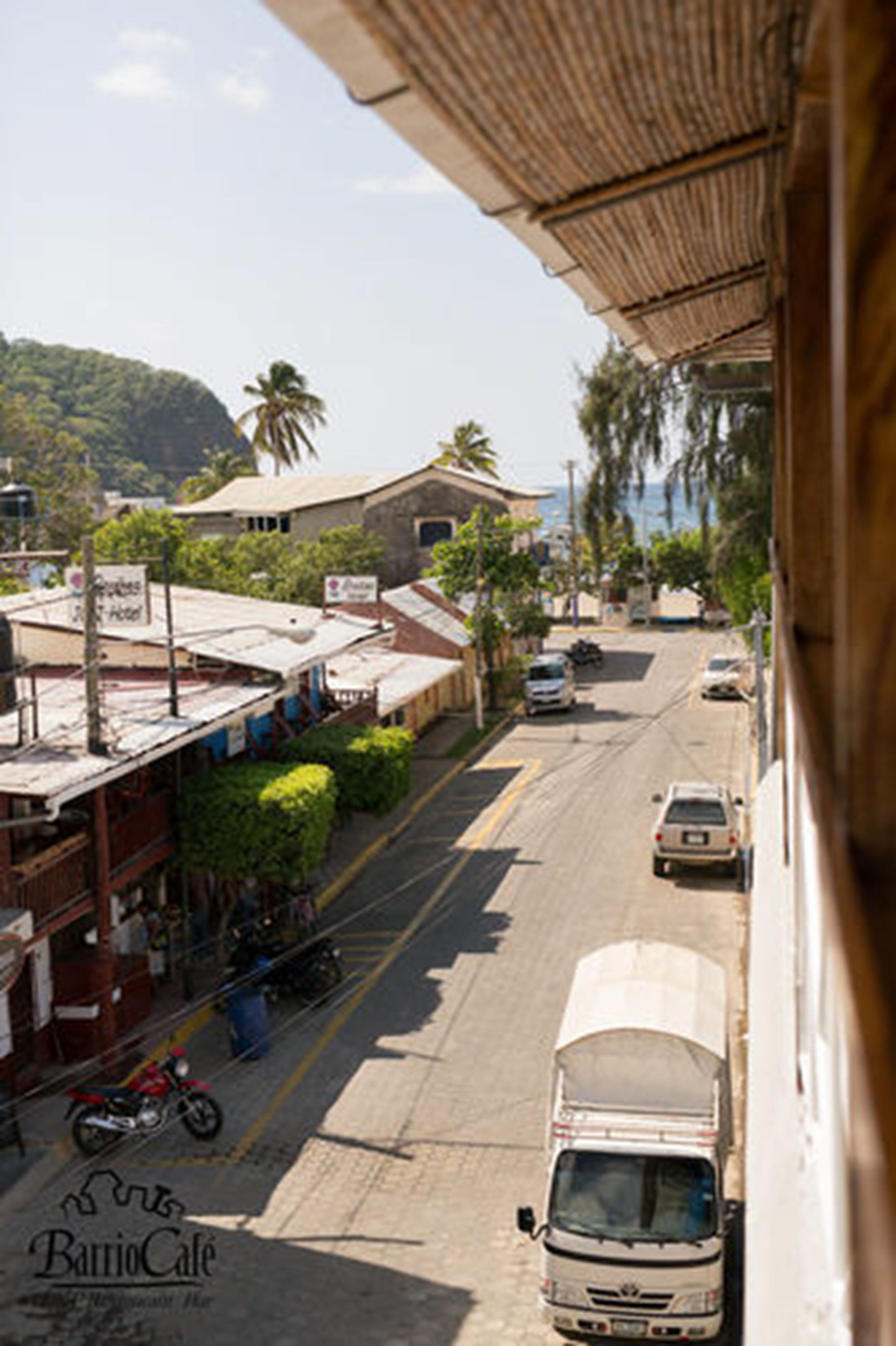 Vista de la calle con un edificio que tiene un letrero que dice 'Barrio Cafe'.