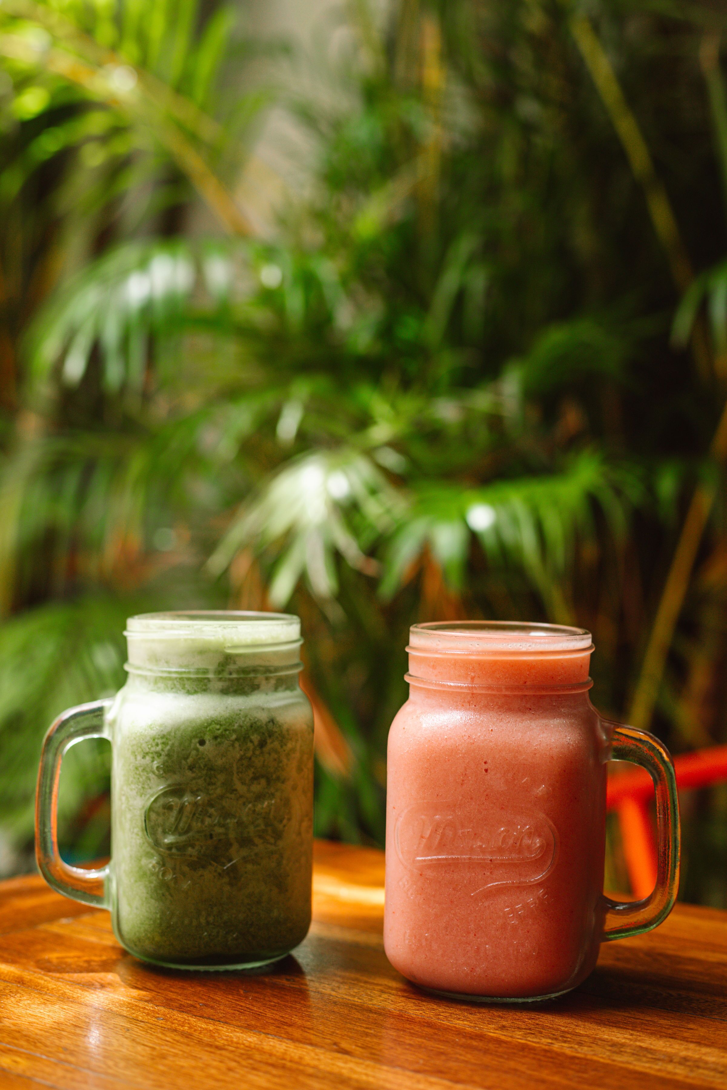 Two glass containers with handles on a wooden surface.