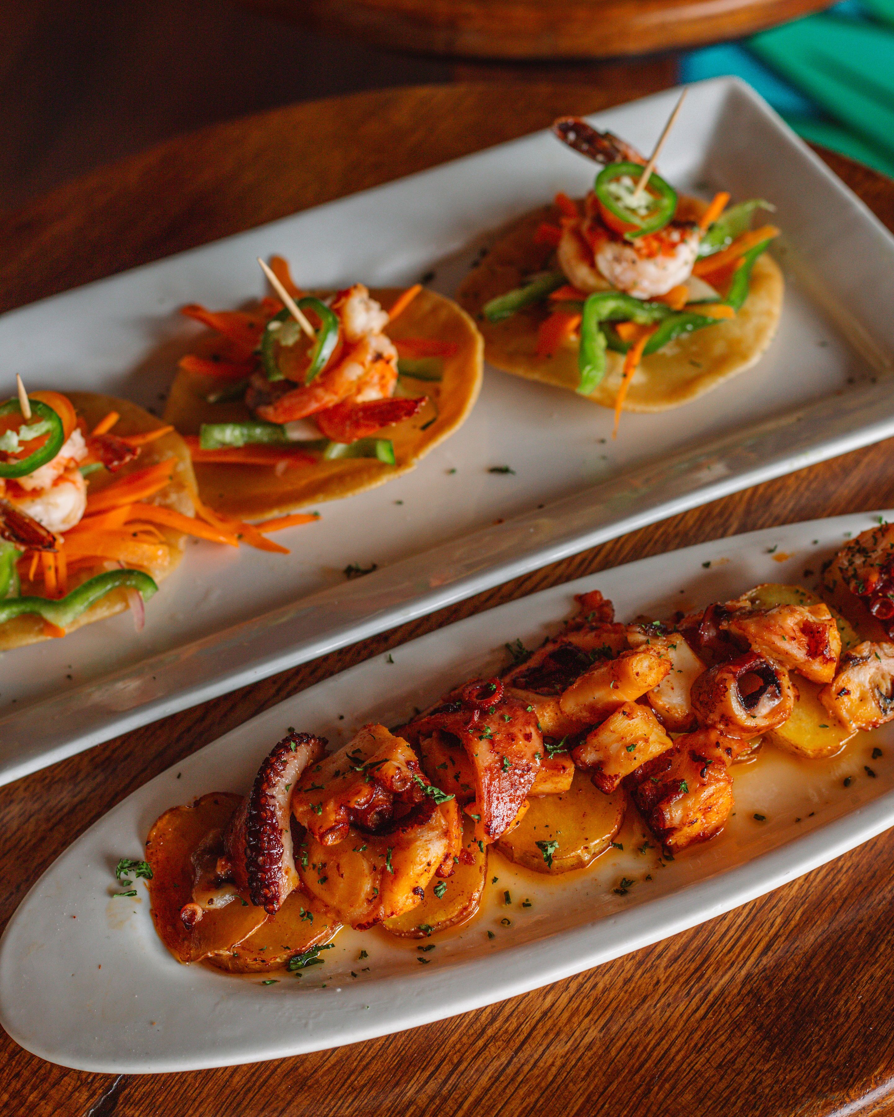 A plate of appetizers with shrimp and vegetables.