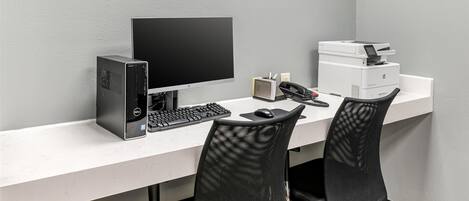 Ein aufgeräumter, moderner Schreibtisch mit Computertisch, Computer, Tastatur, Maus und Drucker.