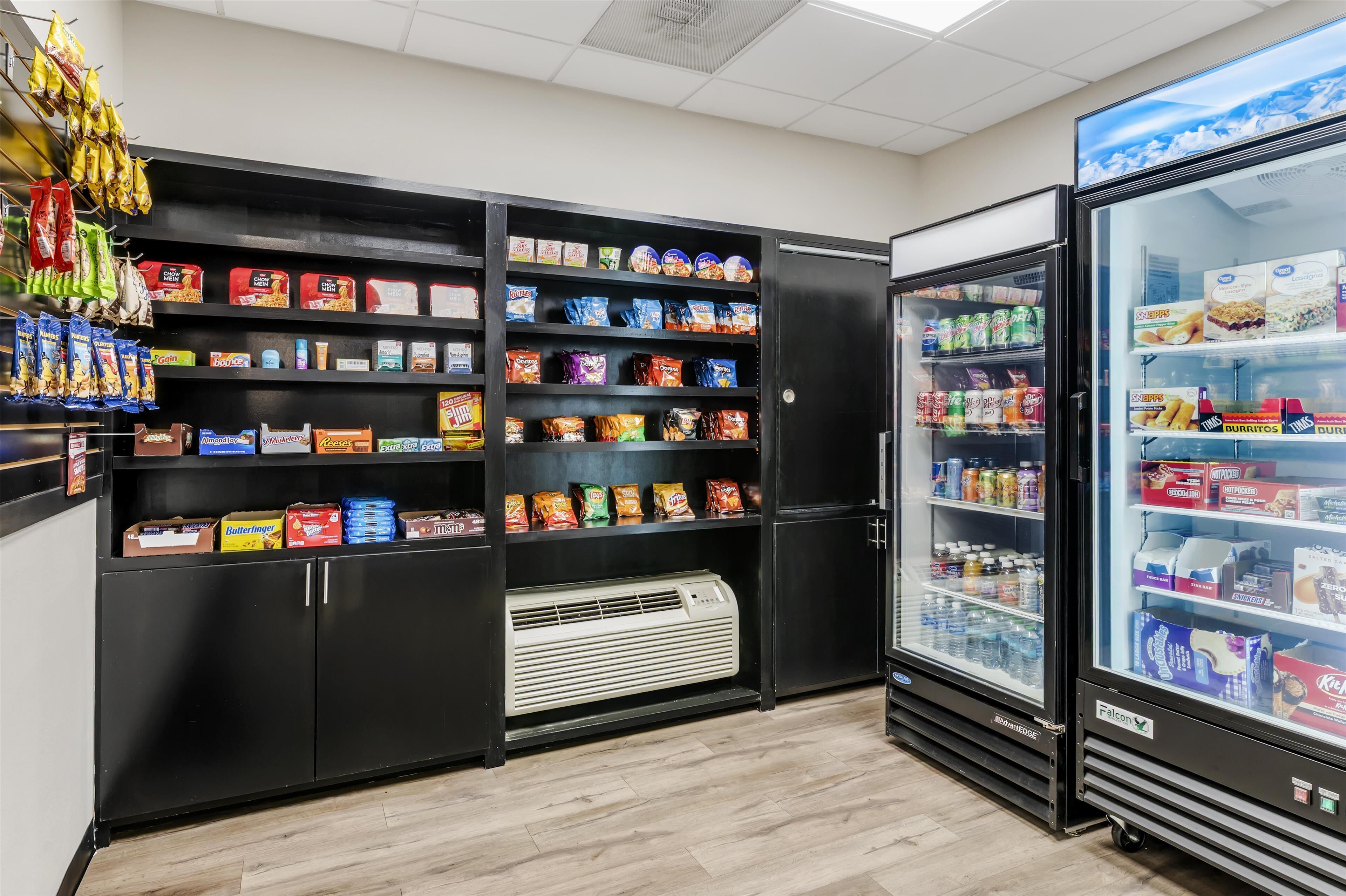Zona de venta automática con varios estantes llenos de aperitivos y bebidas.