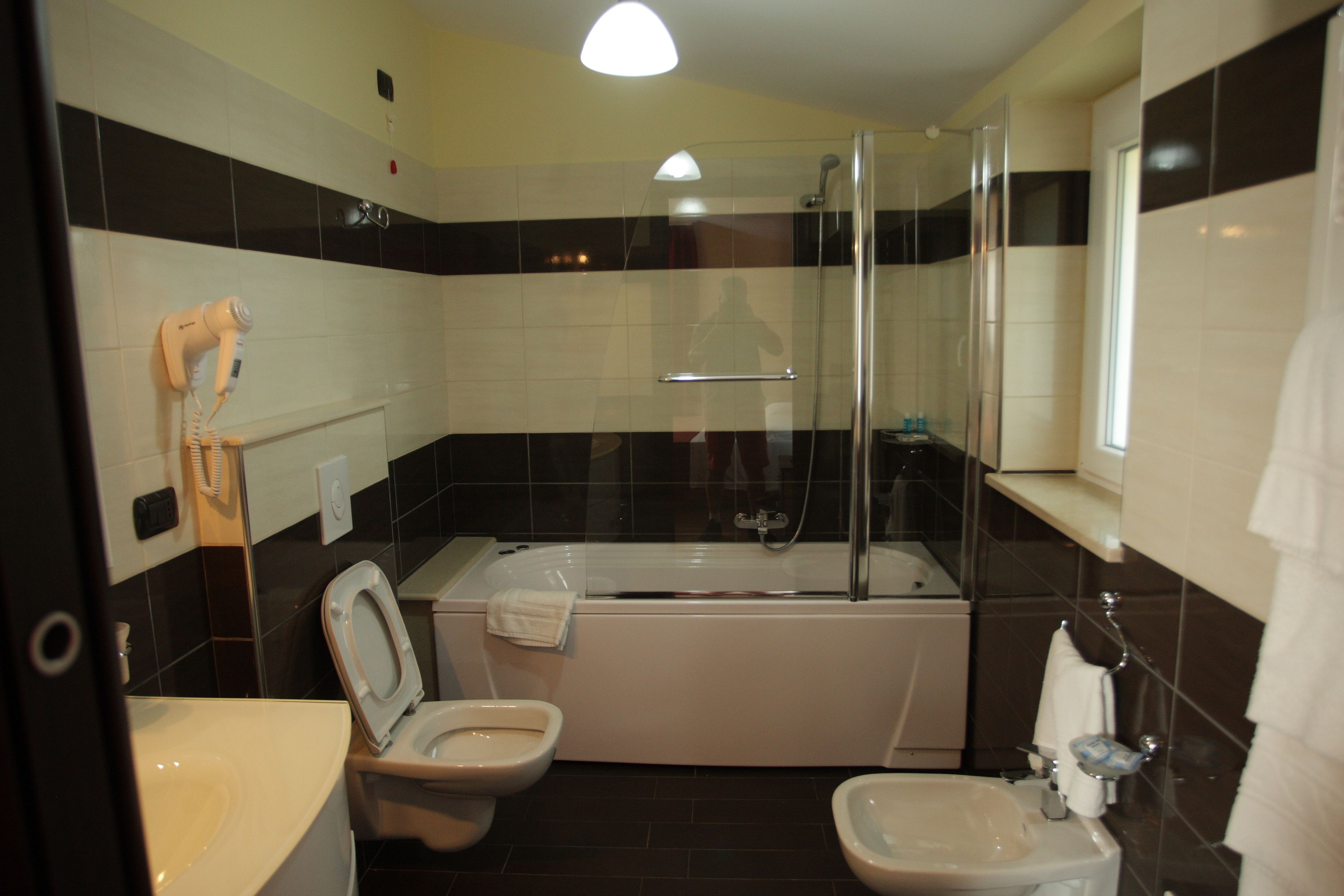 Een badkamer met een bad, toilet en wastafel.