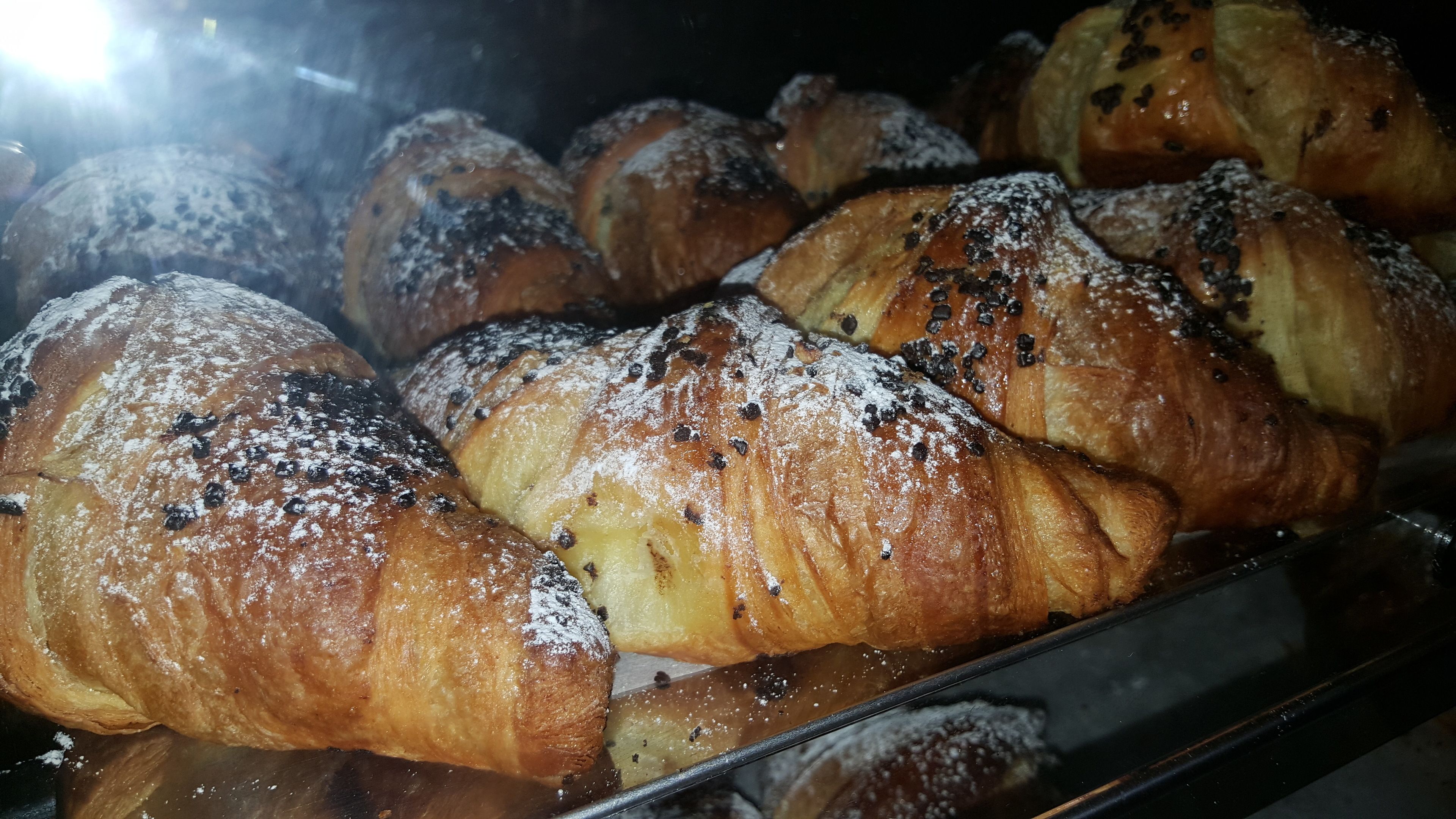 A display of freshly baked croissants in a bakery.