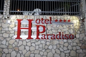 Cartel de hotel con el nombre 'HP Paradiso' y tres estrellas.