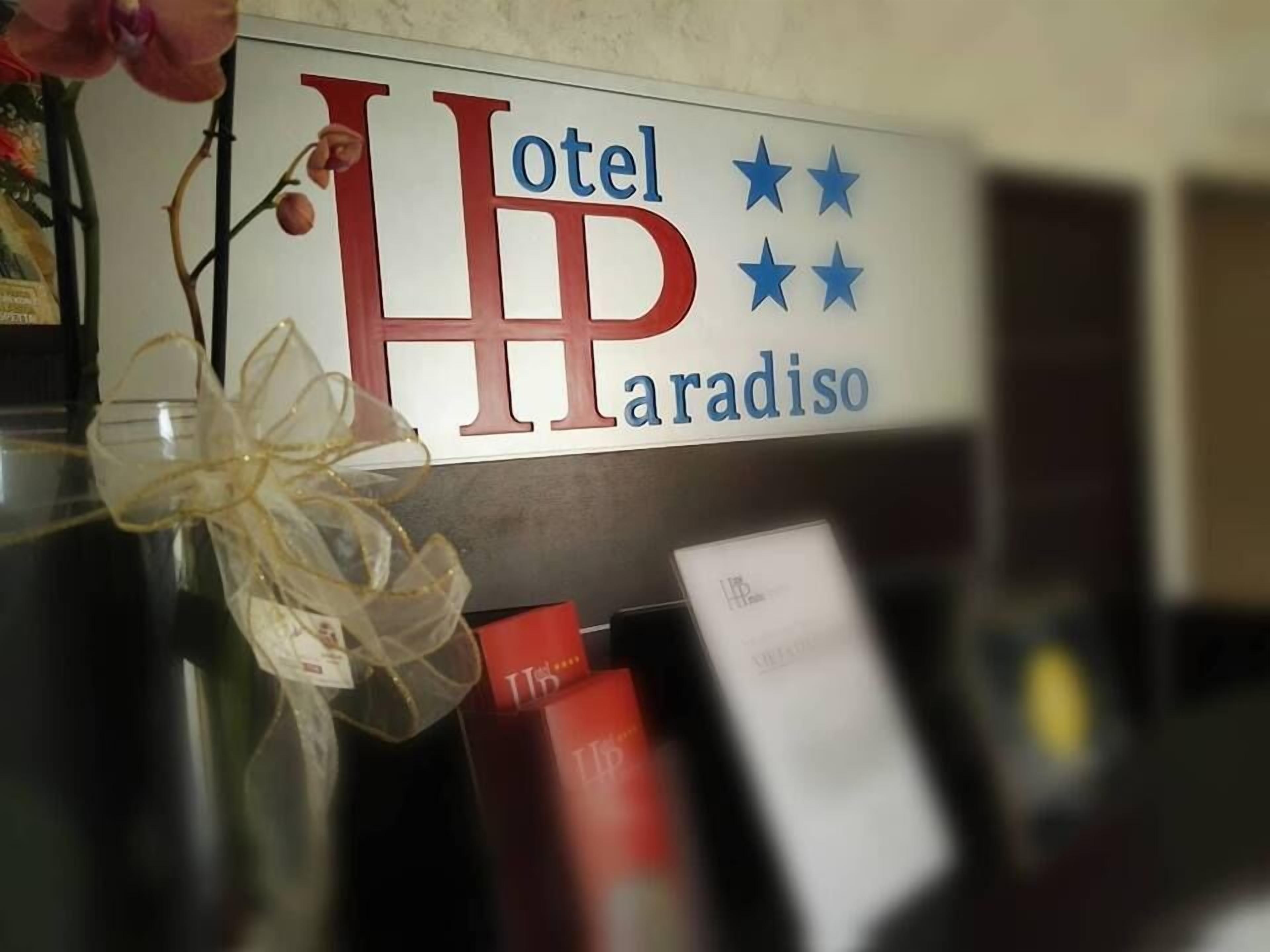 Een hotelschild met de naam 'Hotel Paradiso' en een logo met drie sterren.