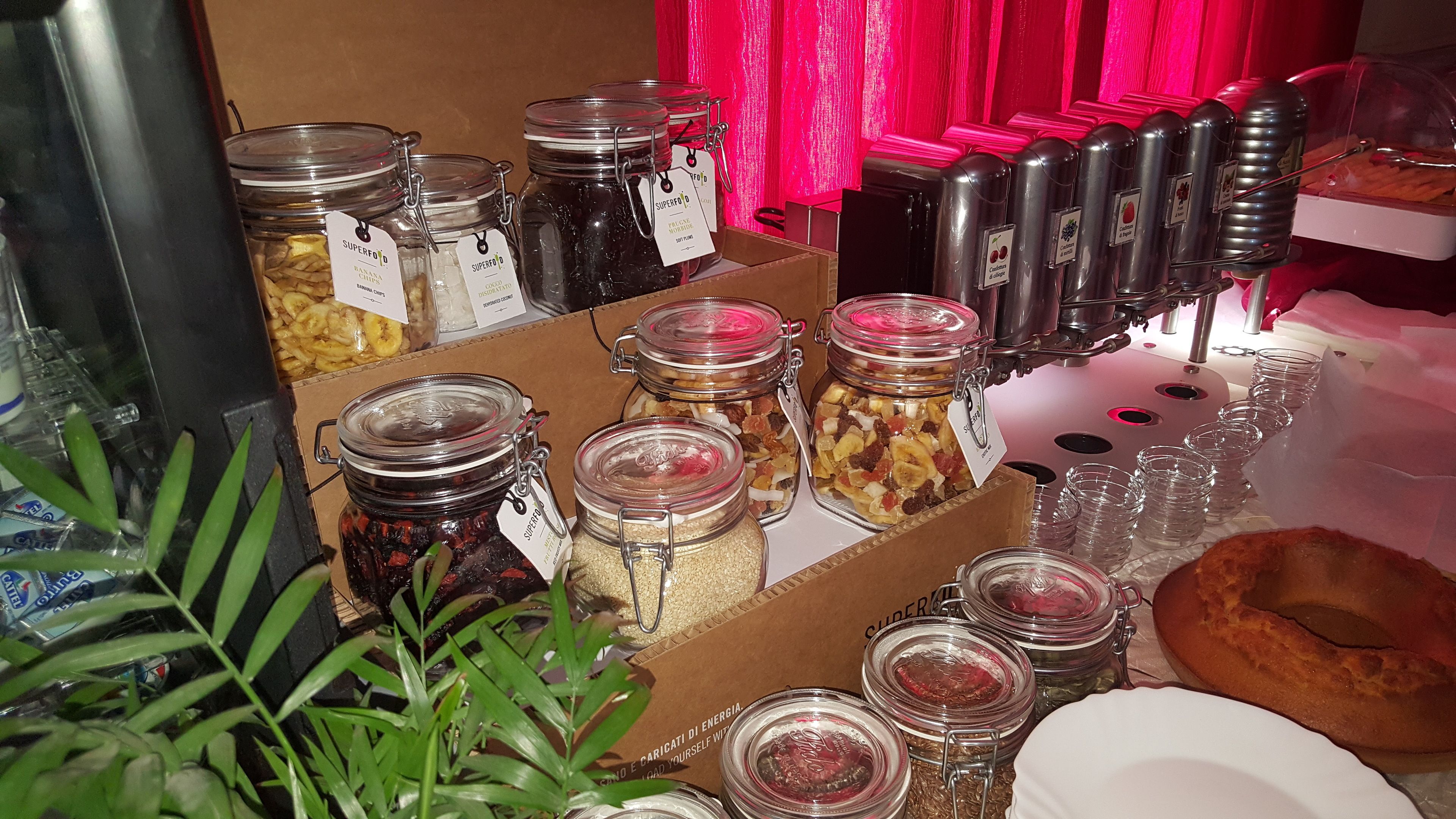 Variedad de alimentos en frascos y recipientes, incluyendo posiblemente mermeladas, conservas y algunas frutas secas.