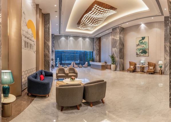 Eine gerĂ€umige Lobby mit Empfangsschalter, Sitzbereich und einem groĂen Fenster mit Blick.
