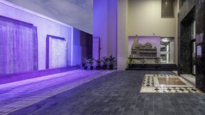 A hotel corridor with a tiled floor, a mural of a temple, and a restaurant sign.