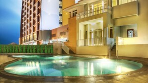 A hotel with a pool area, a large building with a 'ibis' sign, and a well-lit entrance. - ibis Padang Hotel (Padang)