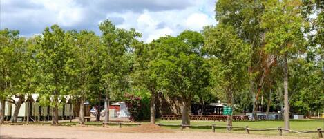 A park with picnic tables and a fenced area.