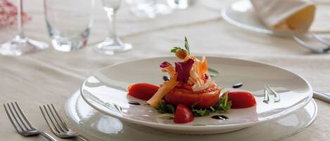 A dining table set with a white plate, silverware, and clear glassware.