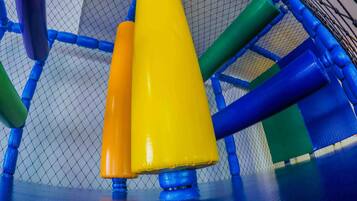 A playground structure with a netted enclosure and colorful poles.