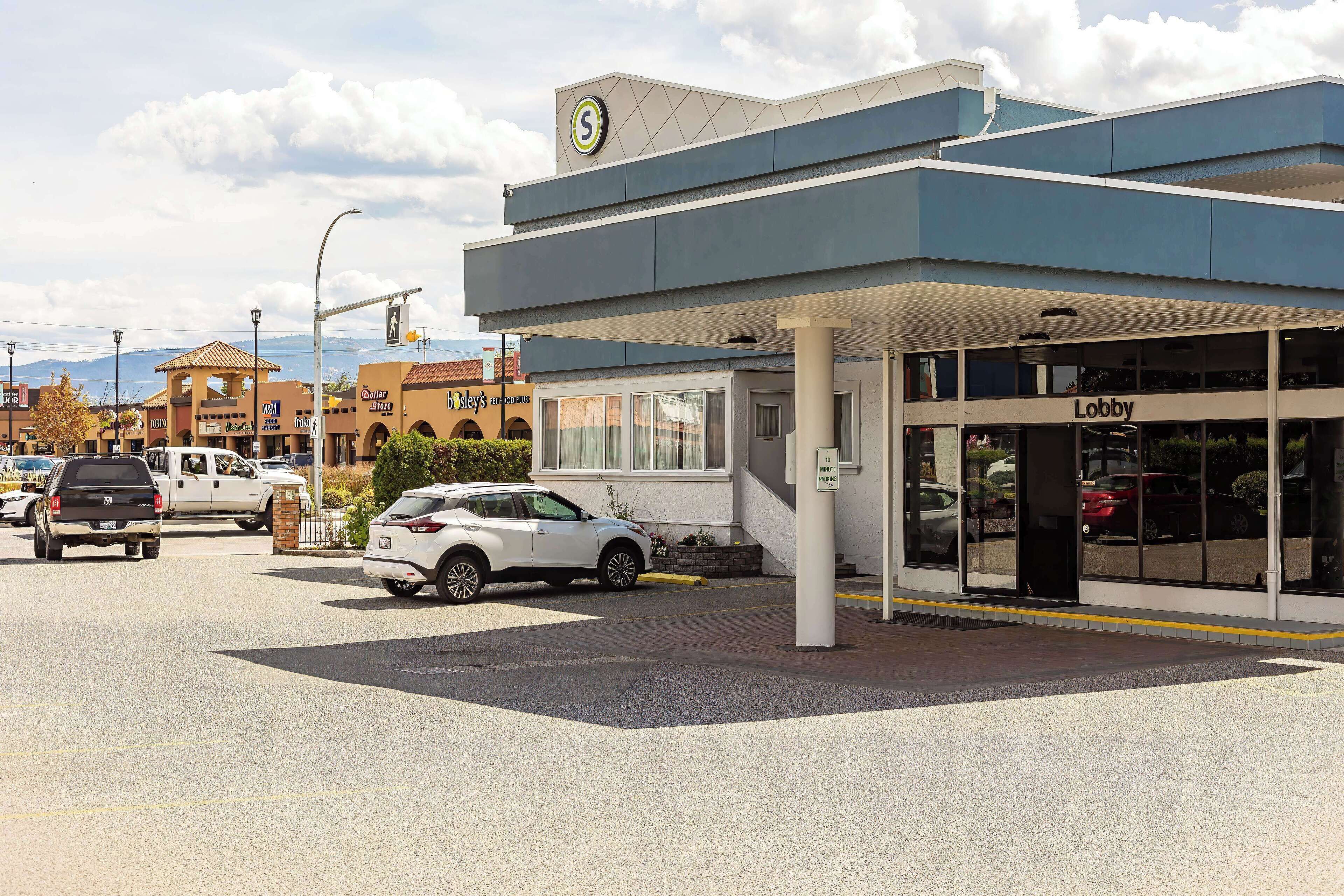 A commercial building with a parking lot, a visible storefront, and a pedestrian crossing.