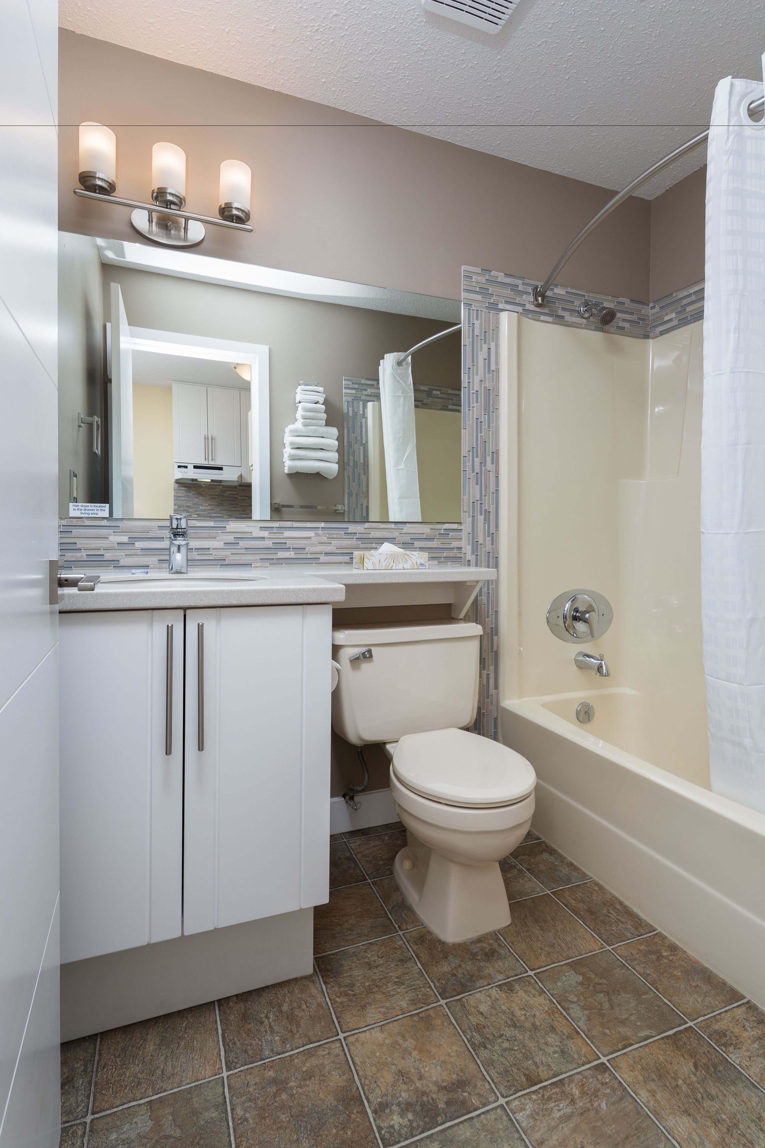 A bathroom with a toilet, sink, and bathtub.