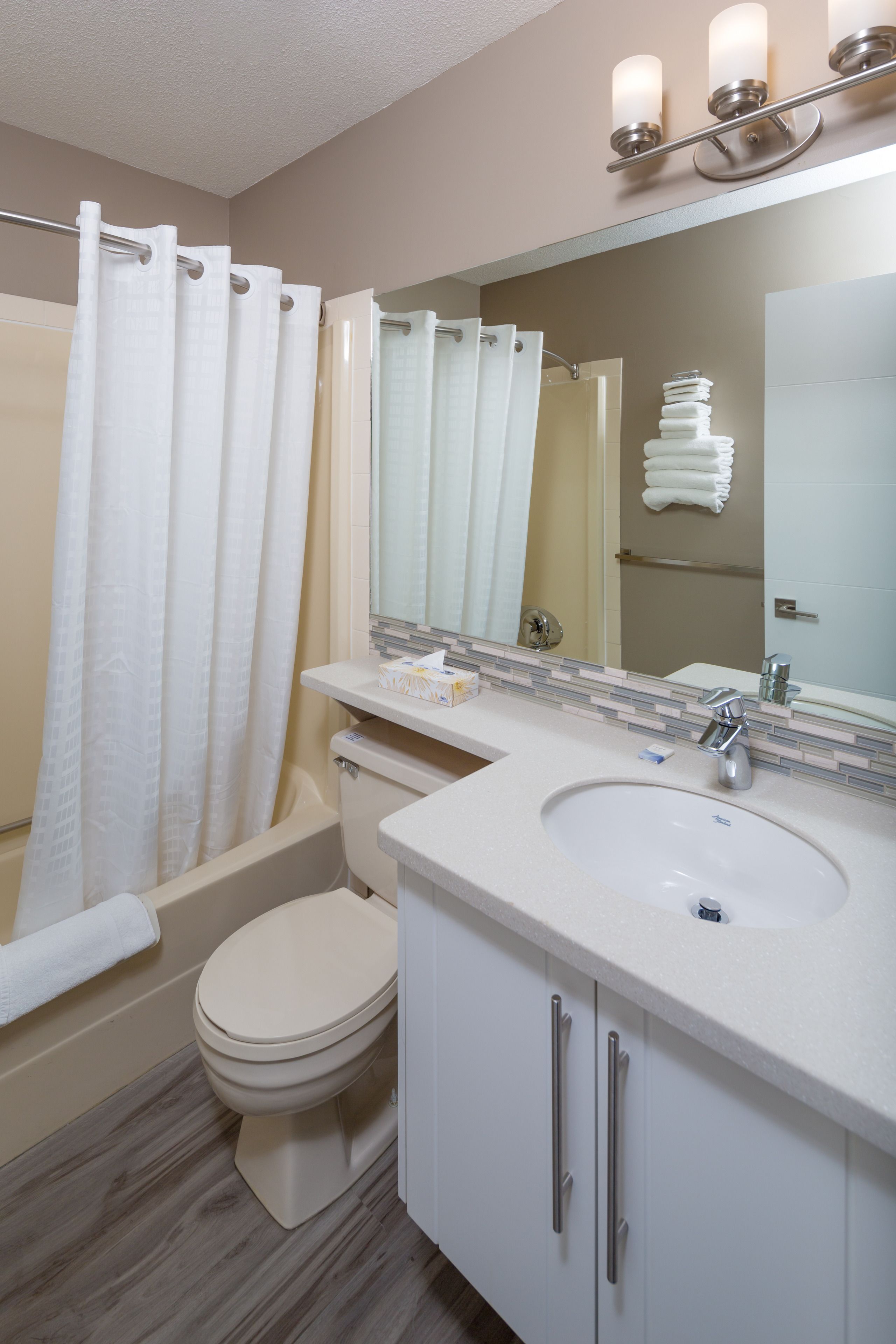 A bathroom with a bathtub, toilet, and sink.