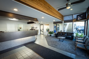 A reception area with a counter, seating, and a television.