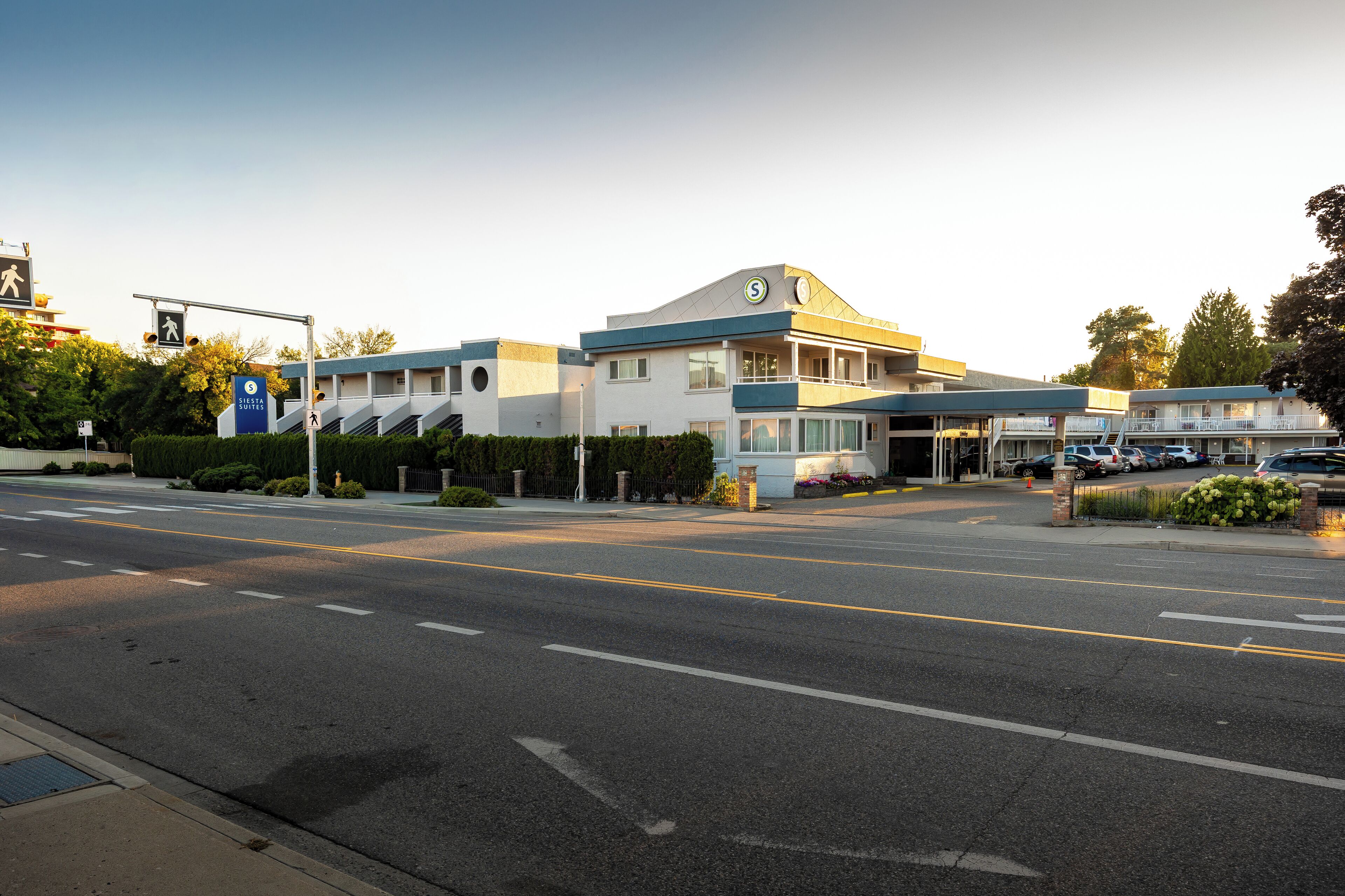 A hotel with a modern design, featuring a prominent 'S' logo on the facade, a covered outdoor area, and a well-maintained parking lot.