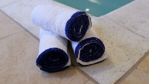 A pool area with a towel and a door in the background.