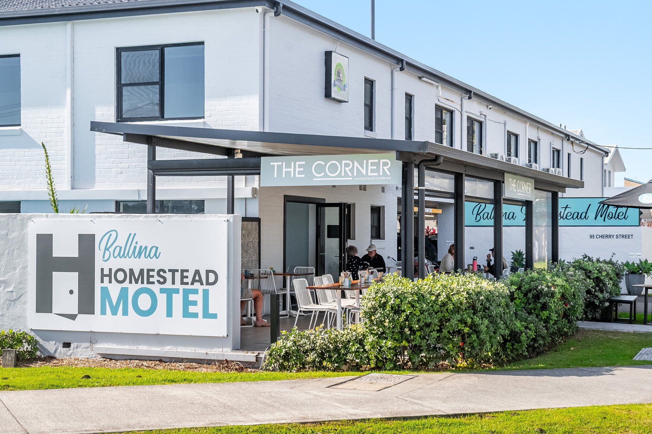 A building with a sign for 'Ballina Homestead Motel' and 'The Corner Coffee Food Catering.'