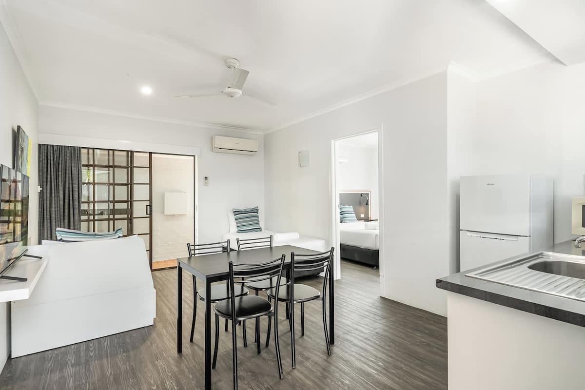 A modern kitchen with a dining area, a ceiling fan, and a built-in refrigerator.