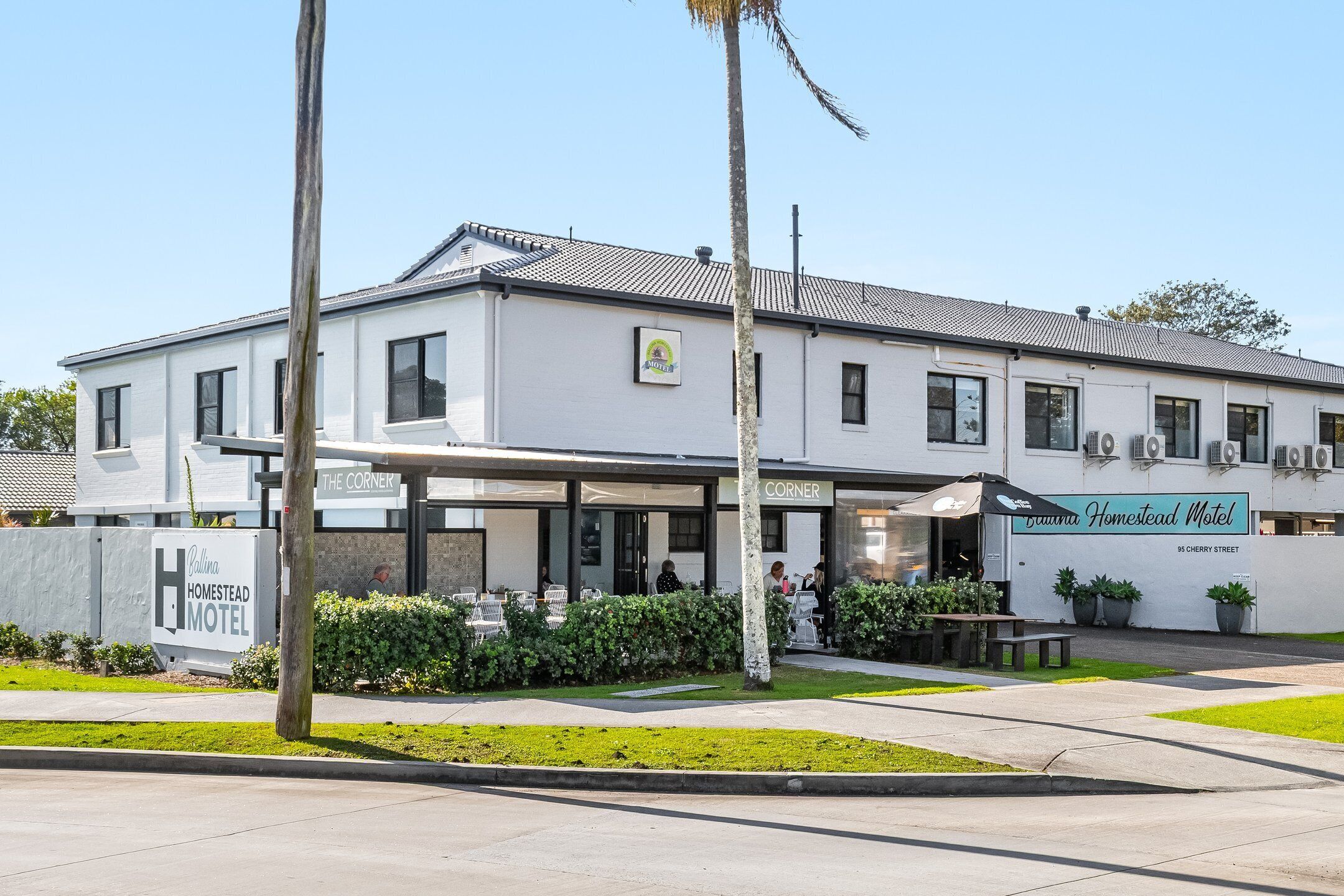 A two-story building with a sign for 'Ballina Homestead Motel' and 'The Corner' restaurant.