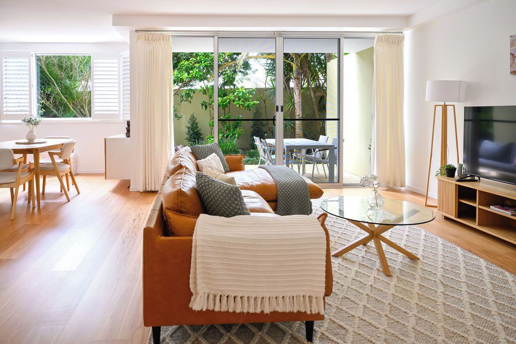 A modern living room with a sofa, coffee table, and TV.