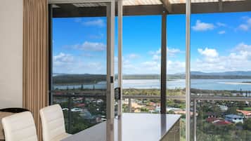 A modern room with a large window offering a view of a lake and surrounding landscape.