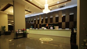 Ein Hotel-Empfangsbereich im modernen Stil, mit einer Rezeption, einer Kristallleuchter und einem Check-in-Schalter.