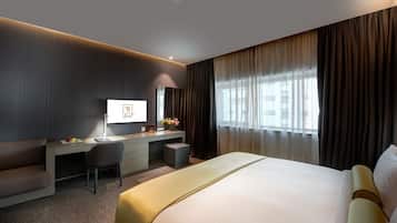 Een moderne hotelkamer met een groot bed, een bureau, een stoel en een televisie.