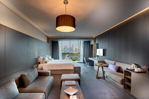 A modern hotel room with a large bed, a sofa, a desk, and a view of a cityscape. - Hotel 72 Sharjah (Sharjah)