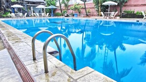 A swimming pool with a tiled edge and a metal ladder. - Sahid Kawanua Manado (Manado)