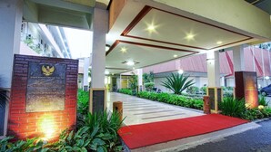 A hotel entrance with a red carpet, a plaque, and a covered walkway. - Sahid Kawanua Manado (Manado)