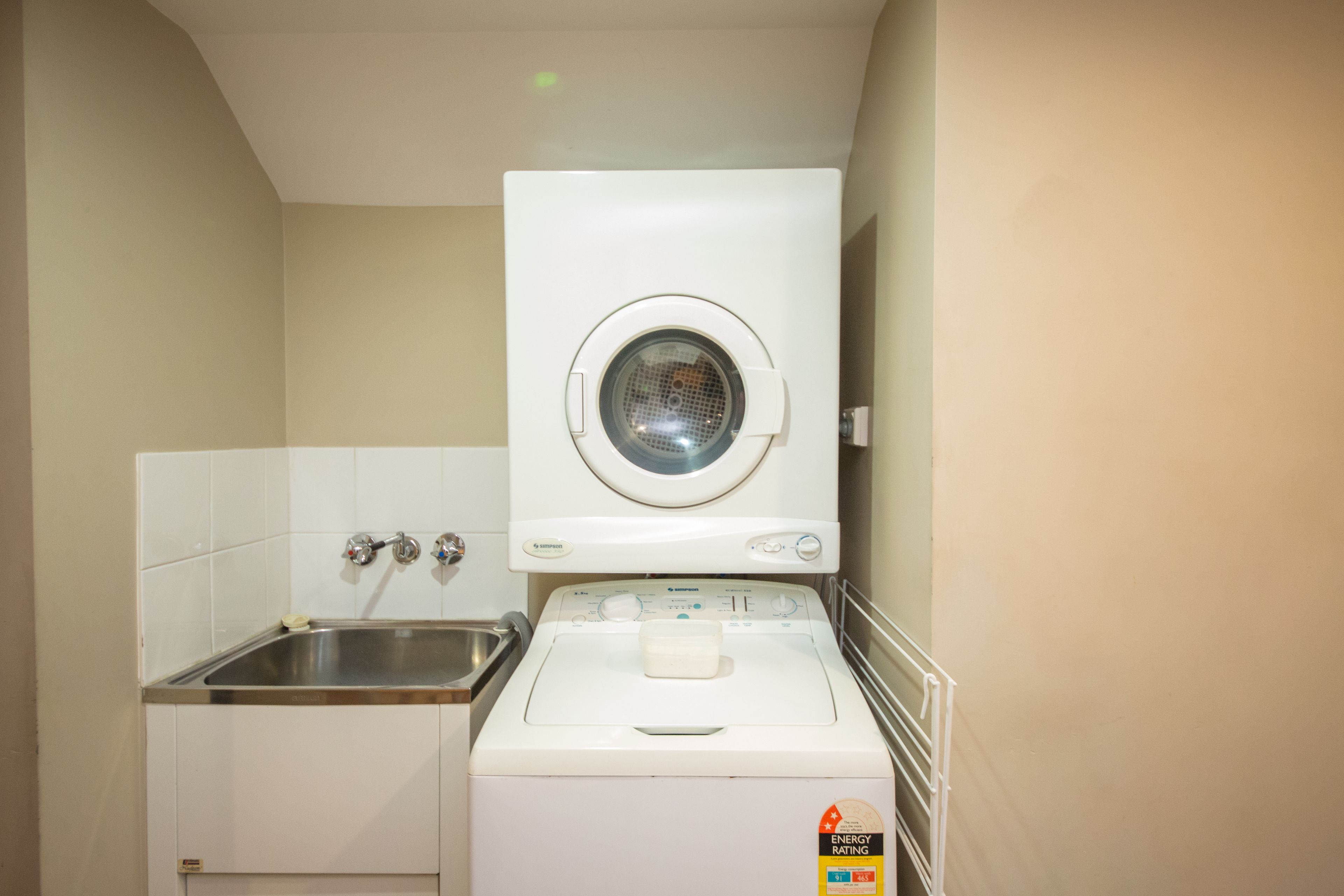 A compact laundry area with a washing machine and a sink.