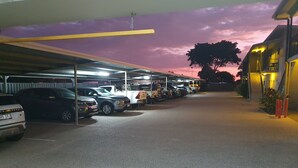 Un estacionamiento con varios automóviles y una camioneta blanca.