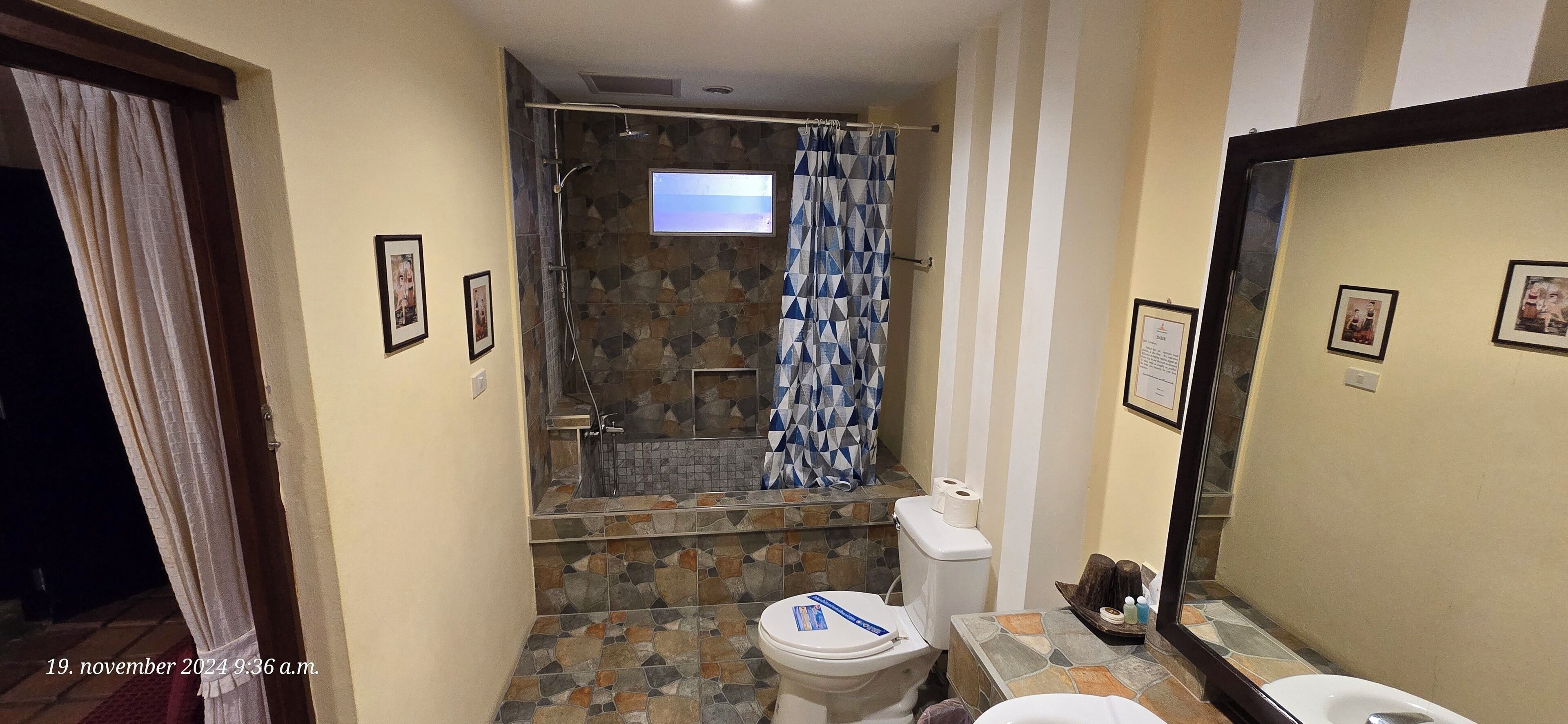 A bathroom with a shower, toilet, and sink.