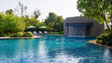 Una piscina al aire libre, tumbonas