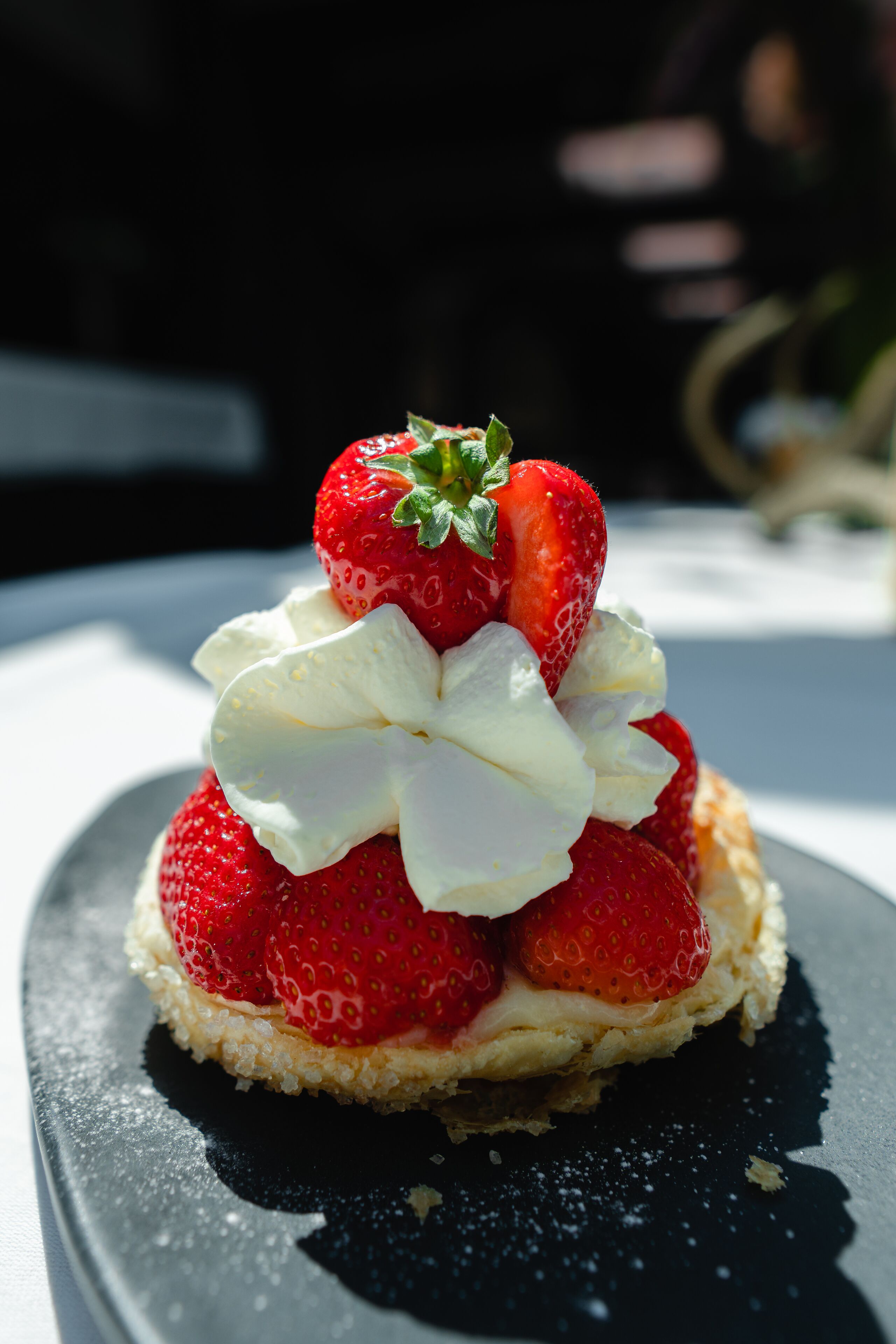 A dessert with strawberries and whipped cream on a plate.