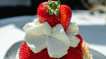 A dessert with strawberries and whipped cream on a plate.
