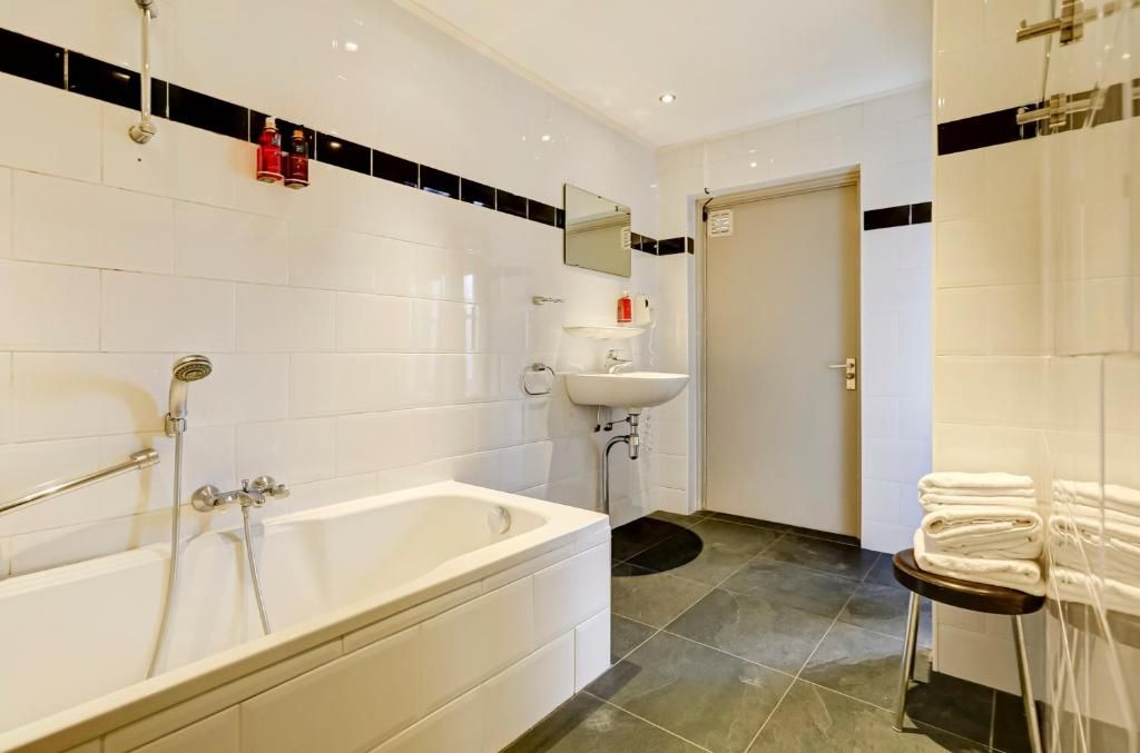 Un baño moderno con bañera, lavabo y espejo.