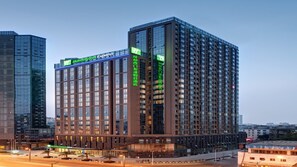 A modern hotel building with a prominent Holiday Inn Express sign, multiple floors, and a glass facade. - Holiday Inn Express Chengdu West Gate by IHG (Chengdu)