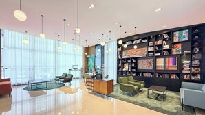 A modern lobby with a large bookshelf, comfortable seating, and a clean, reflective floor. - Holiday Inn Express Chengdu West Gate by IHG (Chengdu)